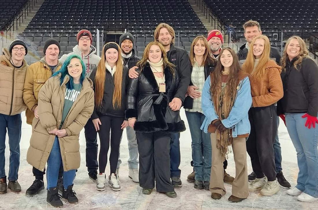 All-Pro Plumbing team smiling together on an ice rink for their 2024 holiday party, representing a positive company culture and work family in Kokomo, IN