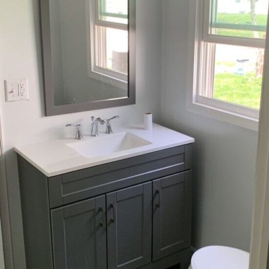 Example of modern bathroom remodel featuring new vanity, sink, mirror, light fixture, and toilet, demonstrating upgrades All-Pro Plumbing can install in Kokomo, IN