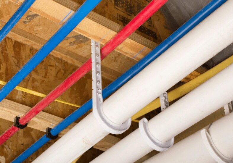 2 PEX water and drain lines repipe uponor pvc dwv all-pro plumbing kokomo indiana Newly installed blue PEX cold water lines, red PEX hot water lines, and white PVC drain pipes in a ceiling, representing modern repiping by All-Pro Plumbing in Kokomo, IN