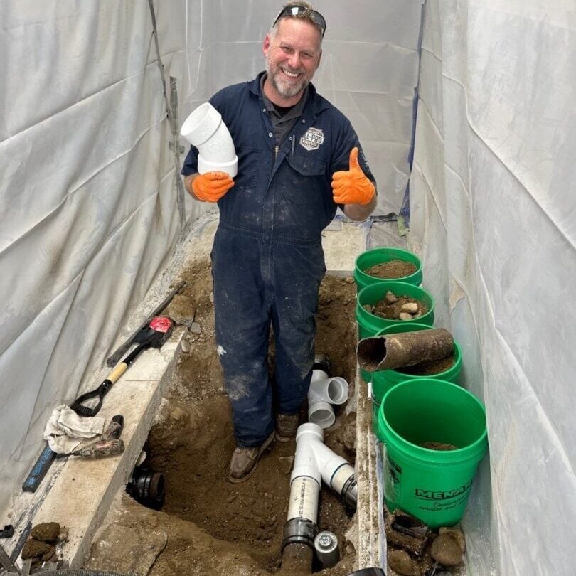 42 Basement, Slab Leaks, Concrete, Under Slab, Broken Drains, Cast Iron All-Pro Plumbing technician repairing slab leak with exposed pipes under concrete floor in Kokomo