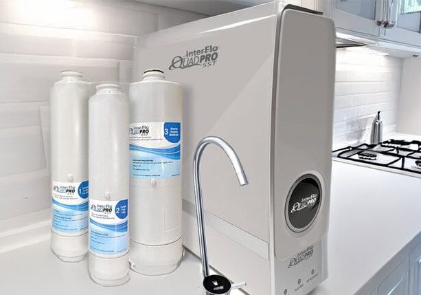 48 QuadPro Tankless RO InterFlo QuadPro SST tankless reverse osmosis unit with extra filters on a modern kitchen counter, representing advanced water filtration systems installed by All-Pro Plumbing in Kokomo, IN