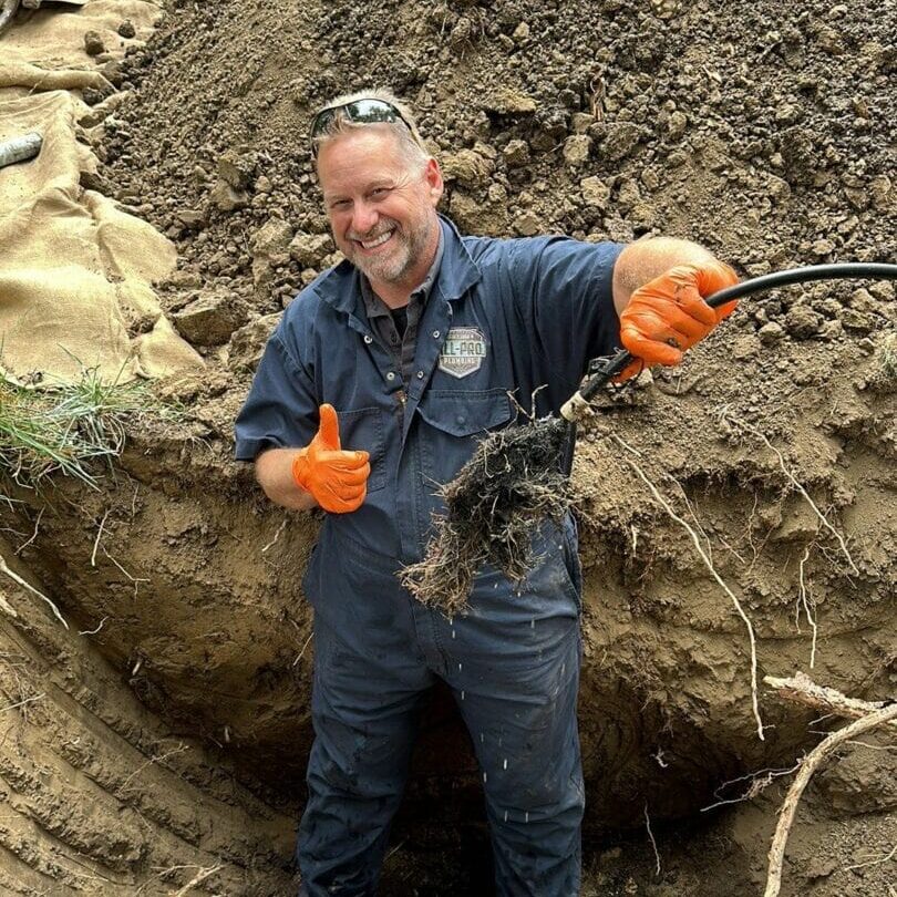 Professional plumber removing roots from a sewer line during a plumbing repair job.