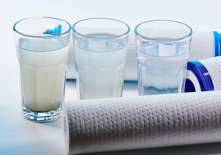 Water filters. Carbon cartridges and glasses on a white background. Household filtration system. Water filters. Carbon cartridges and glasses on a white background. Household filtration system.