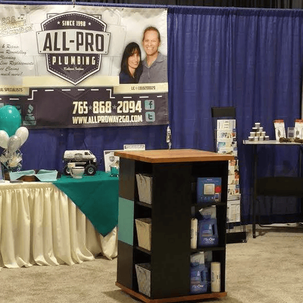 All-Pro Plumbing booth at a local Kokomo, Indiana home show with branded signage, promotional materials, and company contact information
