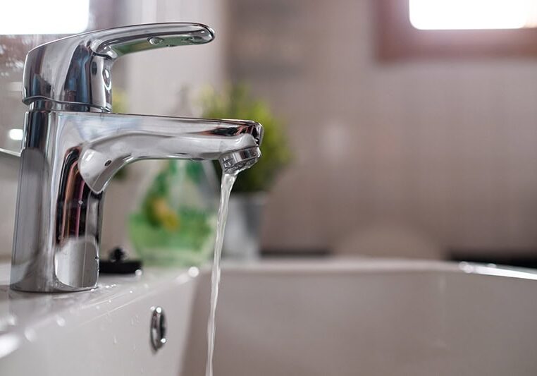 Bathroom lavatory faucet with a weak stream of water, indicating low water flow or pressure from improperly sized or constricted water lines, requiring repipe service by All-Pro Plumbing in Kokomo, IN